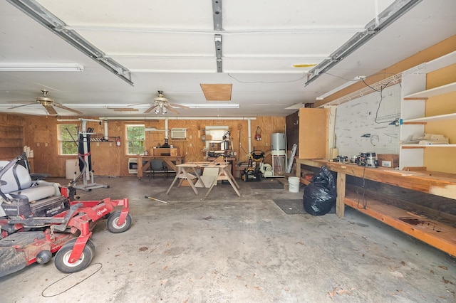 garage with water heater, wooden walls, and a workshop area