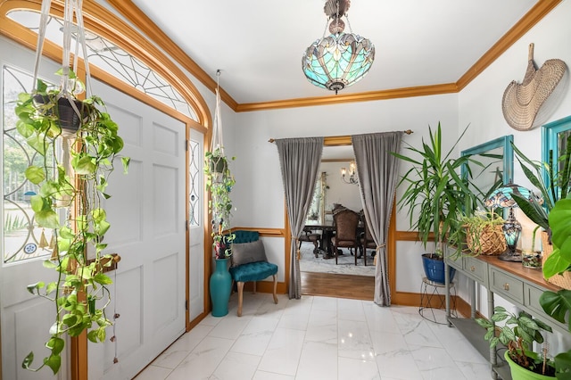 entryway with a notable chandelier and ornamental molding