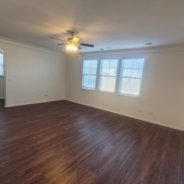 empty room featuring a ceiling fan, baseboards, dark wood-type flooring, and crown molding