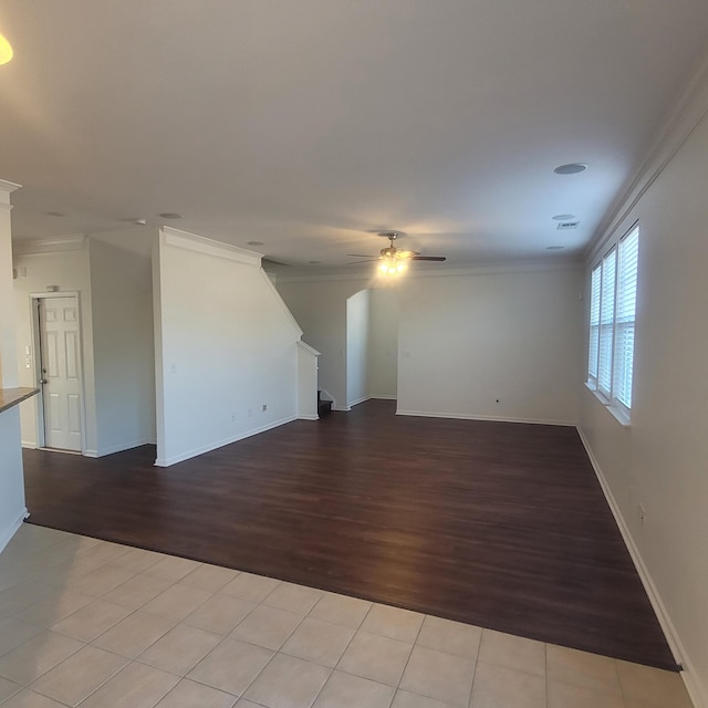 empty room featuring ornamental molding, wood finished floors, and a ceiling fan