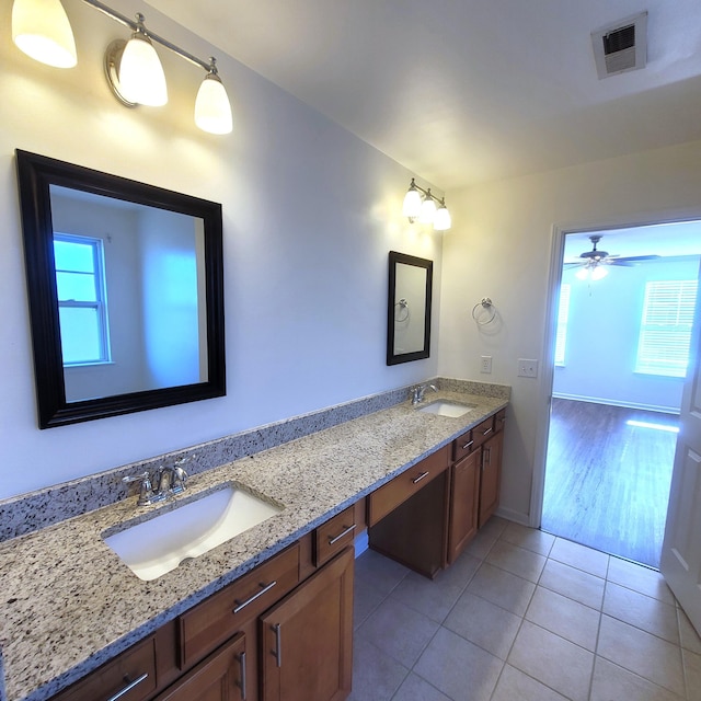 bathroom with double vanity, visible vents, a sink, and tile patterned floors