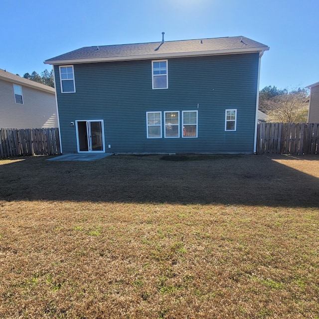 back of property with a patio area, a fenced backyard, and a yard