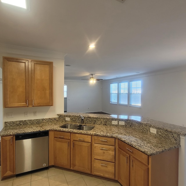 kitchen featuring brown cabinetry, stone countertops, a sink, and stainless steel dishwasher