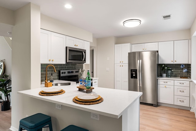 1478 Diamond Blvd, Mount Pleasant, SC 29466 - kitchen featuring appliances with stainless steel finishes, backsplash, a peninsula, light countertops, and recessed lighting