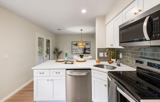 1478 Diamond Blvd, Mount Pleasant, SC 29466 - kitchen with appliances with stainless steel finishes, a peninsula, backsplash, white cabinetry, and light countertops