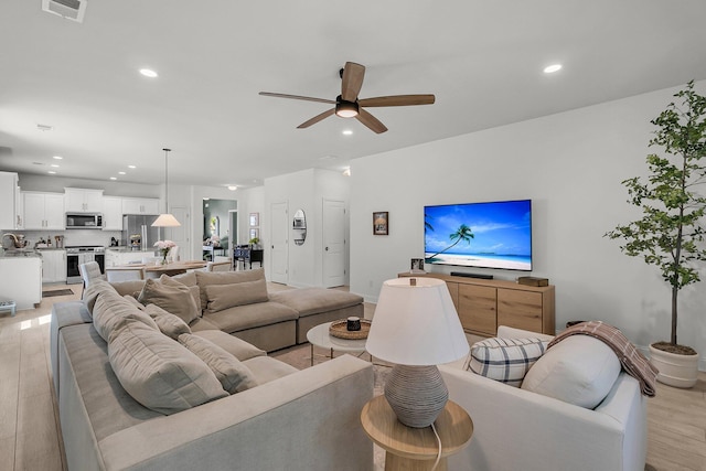 living area with ceiling fan, light wood-type flooring, recessed lighting, and visible vents
