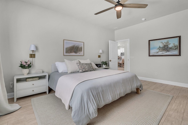 bedroom with baseboards, a ceiling fan, and light wood-style flooring