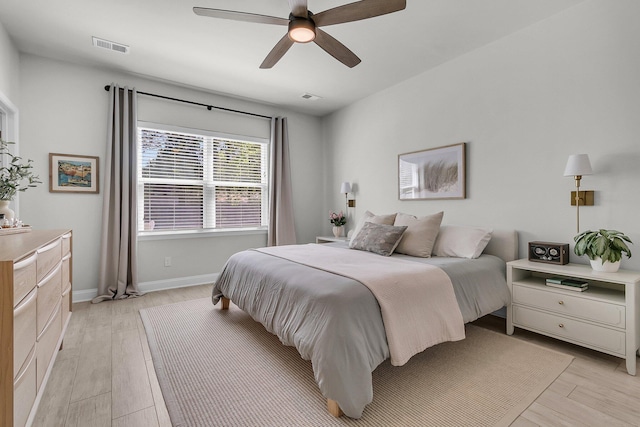 bedroom featuring baseboards, visible vents, ceiling fan, and light wood-style flooring
