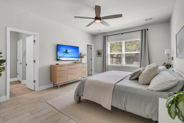 bedroom featuring baseboards, ceiling fan, light wood finished floors, and visible vents