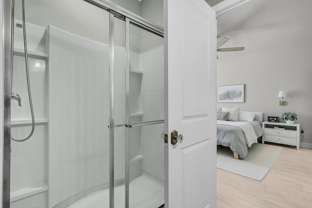 full bath with ceiling fan, a stall shower, and wood finished floors