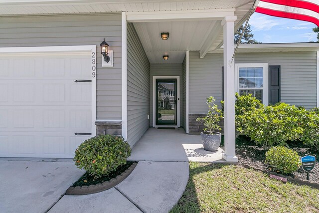 entrance to property with a porch and a garage