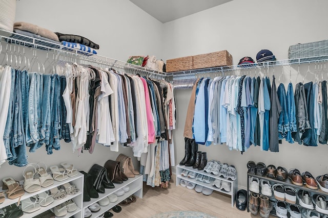 walk in closet with wood finished floors