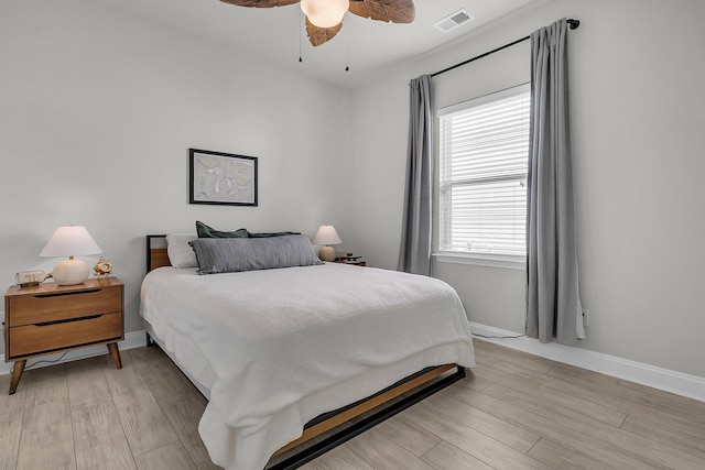 bedroom featuring ceiling fan, baseboards, visible vents, and light wood-style flooring