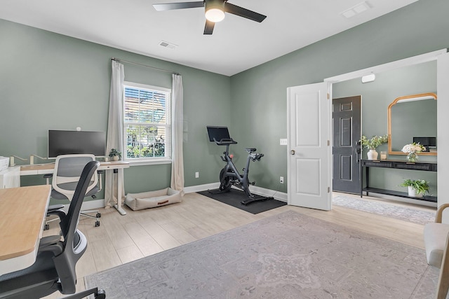 home office with a ceiling fan, baseboards, visible vents, and wood finished floors