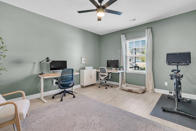 home office with a ceiling fan, baseboards, visible vents, and wood finished floors