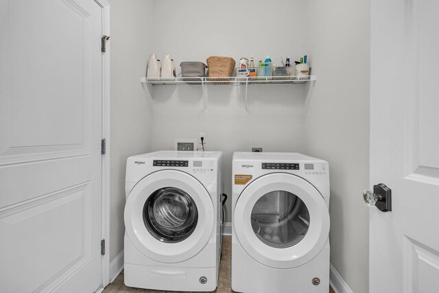 washroom with baseboards, laundry area, and washer and clothes dryer