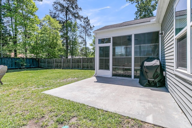 view of yard with a patio, a fenced backyard, and a sunroom