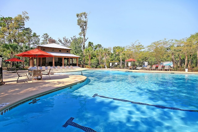 pool with a patio area and fence