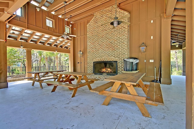 view of patio featuring fence, a ceiling fan, and an outdoor brick fireplace