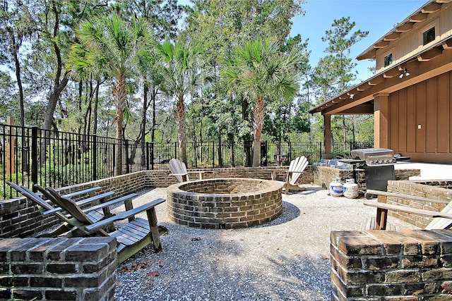view of patio featuring a fenced backyard, an outdoor fire pit, and a grill