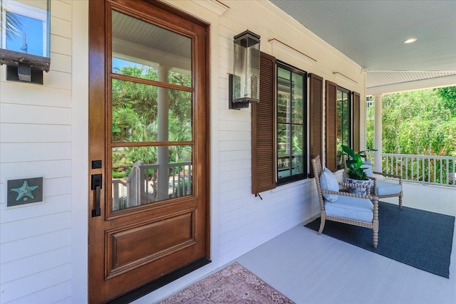 view of exterior entry featuring covered porch