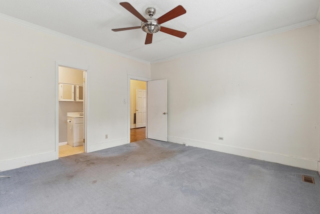 empty room with crown molding, visible vents, light carpet, ceiling fan, and baseboards