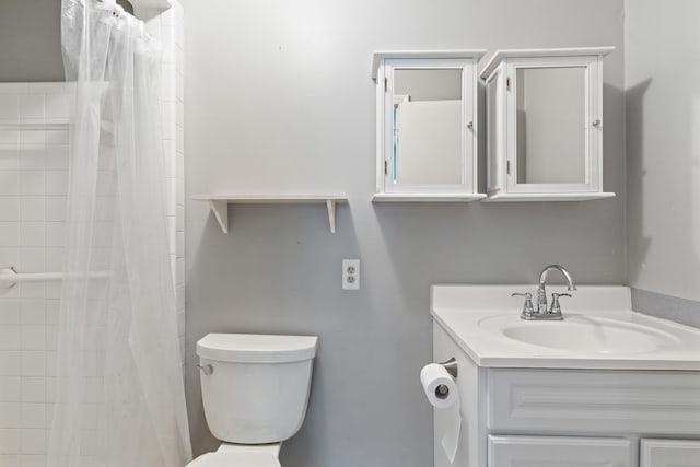 bathroom featuring toilet, curtained shower, and vanity