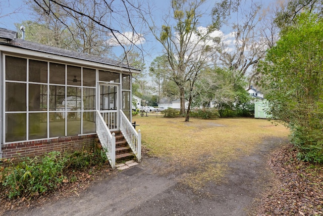 view of yard with entry steps and a sunroom