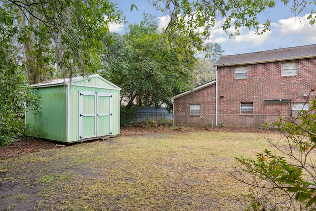 view of yard featuring fence, a storage unit, and an outdoor structure