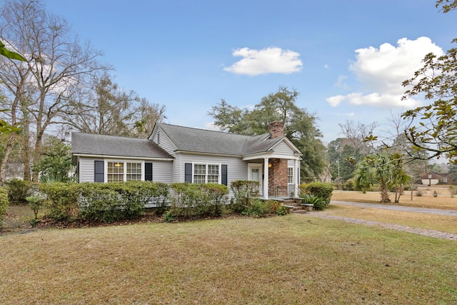 view of front of property featuring a chimney and a front lawn