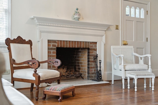 sitting room featuring a fireplace and wood finished floors