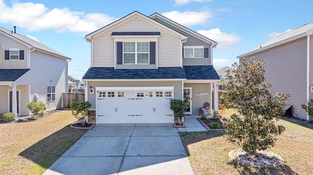 view of front of house with driveway, an attached garage, fence, and a front yard