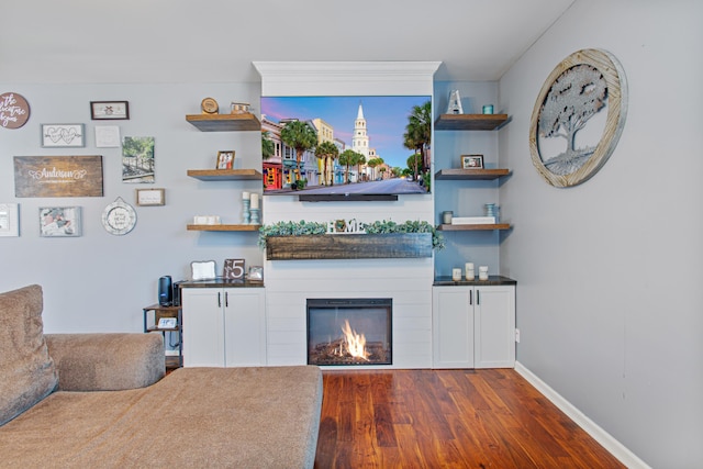 bar featuring dark wood-style floors, a glass covered fireplace, and baseboards