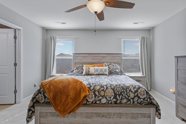 bedroom with carpet floors, visible vents, and multiple windows