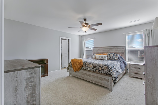 carpeted bedroom with visible vents and ceiling fan