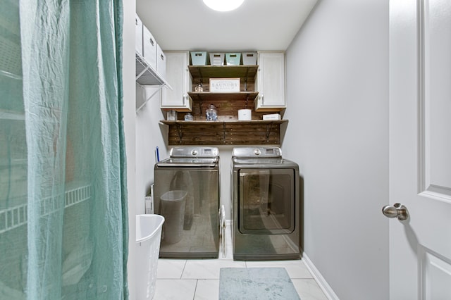 washroom with cabinet space, baseboards, and separate washer and dryer