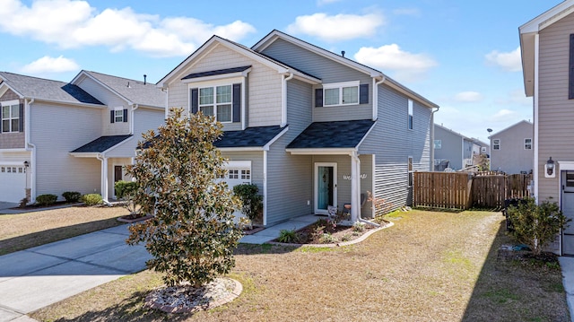 view of front facade featuring a garage, a front yard, and fence