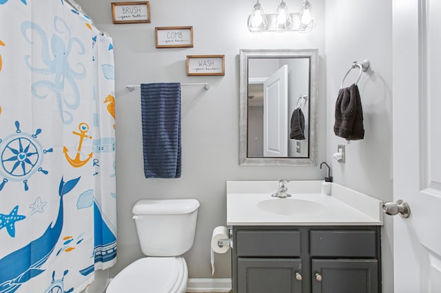 bathroom with toilet, a shower with shower curtain, vanity, and baseboards