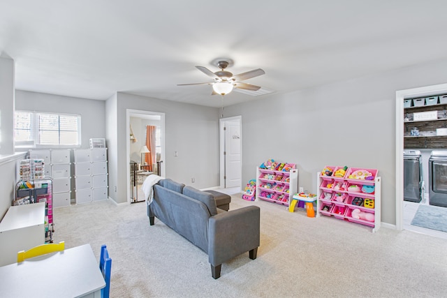 playroom featuring carpet floors, washing machine and dryer, baseboards, and ceiling fan