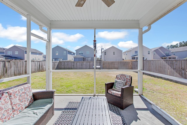 sunroom / solarium with a residential view and ceiling fan