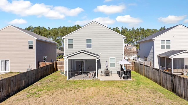 back of house featuring a sunroom, a fenced backyard, a patio area, and a yard