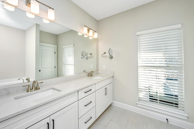 bathroom with a healthy amount of sunlight, vanity, and tile patterned flooring