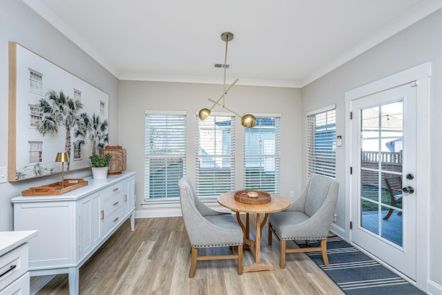 dining area featuring crown molding, a healthy amount of sunlight, a chandelier, and light wood-type flooring