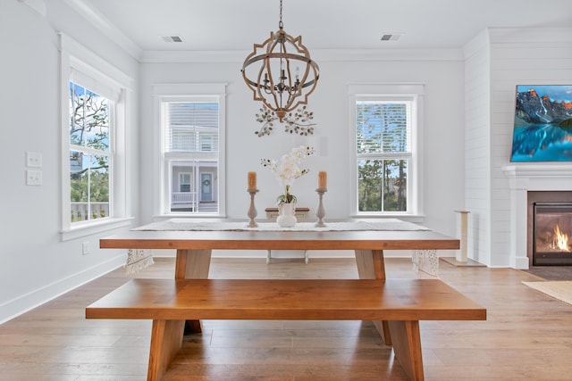 840 Forrest Dr, Charleston, SC 29492 - unfurnished dining area featuring healthy amount of natural light, a chandelier, wood finished floors, a large fireplace, and crown molding