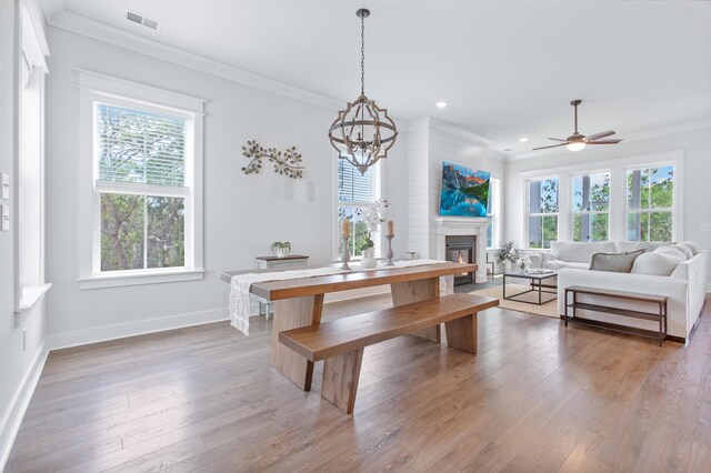 840 Forrest Dr, Charleston, SC 29492 - dining room with ornamental molding, wood-type flooring, a glass covered fireplace, a chandelier, and baseboards