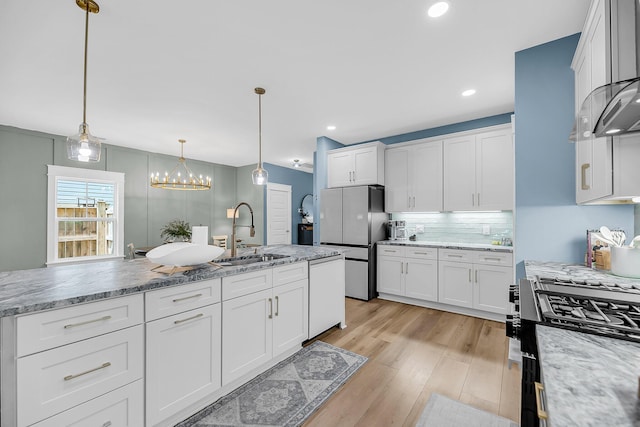 331 Saddlewood Dr, Charleston, SC 29414 - kitchen featuring appliances with stainless steel finishes, light wood-type flooring, tasteful backsplash, white cabinets, and decorative light fixtures