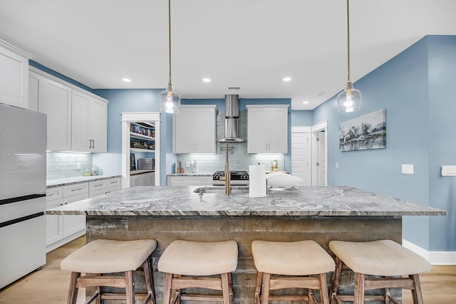 331 Saddlewood Dr, Charleston, SC 29414 - kitchen with freestanding refrigerator, wall chimney exhaust hood, decorative backsplash, a kitchen bar, and recessed lighting