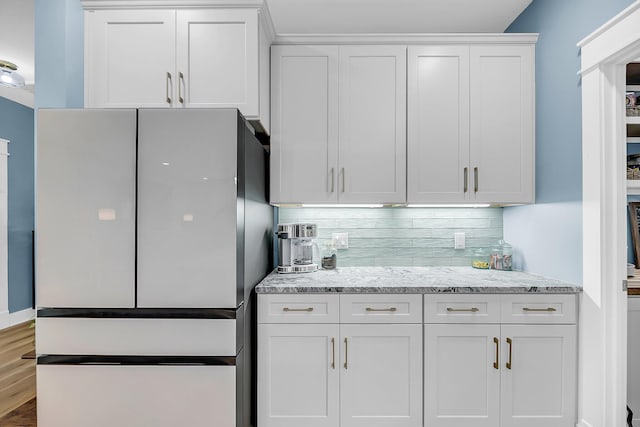 331 Saddlewood Dr, Charleston, SC 29414 - kitchen with freestanding refrigerator, white cabinetry, backsplash, light stone countertops, and wood finished floors