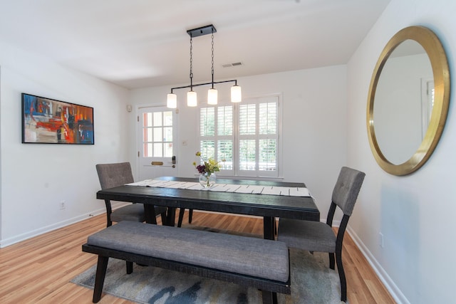 dining room featuring light wood-style flooring and baseboards