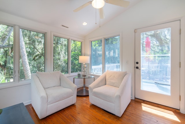 sunroom / solarium featuring plenty of natural light, vaulted ceiling, hardwood / wood-style flooring, and a wooden deck